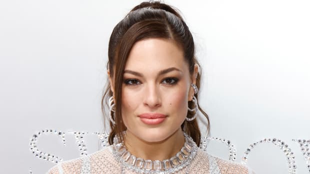 Ashley Graham poses in a dress made of Swarovski crystals and smiles for the camera.